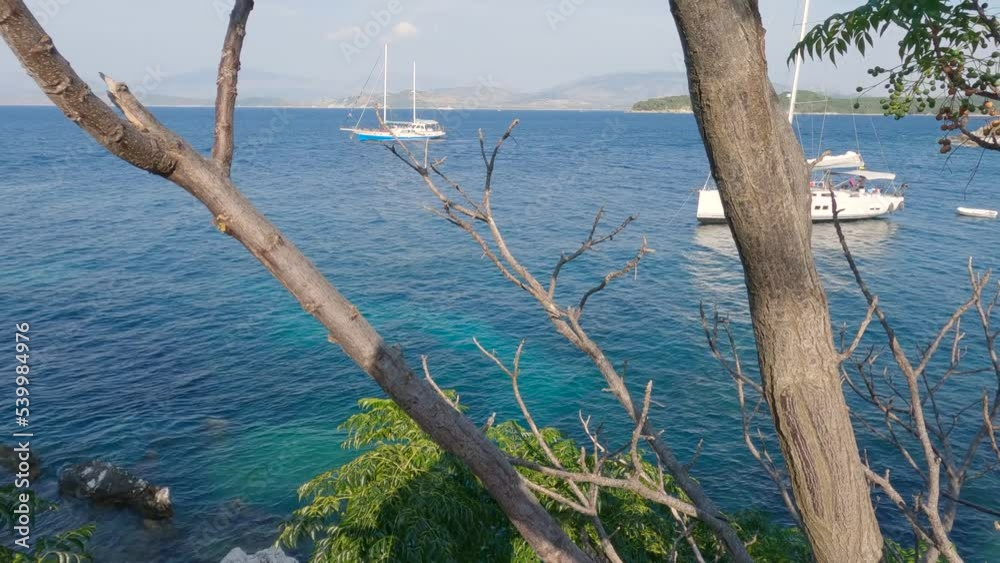 Anchored sailboats along the coast of the island Corfu, fishing village Kassiopi, Greece Anchored sailboats along the coast of the island Corfu, fishing village Kassiopi, Greece