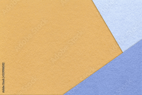 Texture of craft light yellow color paper background with blue and very peri border. Vintage abstract ocher cardboard.