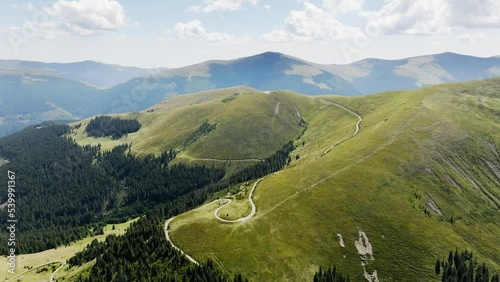Aerial view of the Transalpina road in Romania. Carpathian Mountains, curvy road, summer, green trees, drone, highlands, scenery, road trip, highway, valleys. 4K 50fps Drone Video Footage