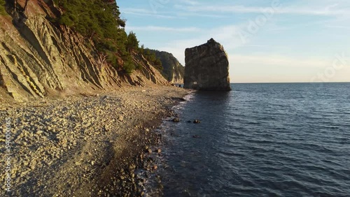 Lonely rock in the form of a wall on the seashore, drone flight