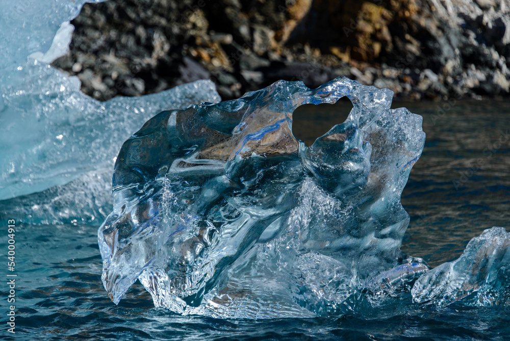 Piece of ice in clean water. Iceberg. Piece of ice in clean water. Iceberg.