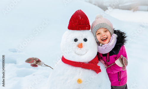 The child made a big snowman and decorated it with a wide smile and clothe © ShunTerra