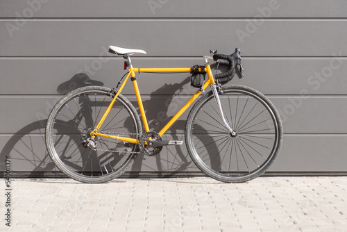 Photography vintage yellow racing bike leaning against a gray wall