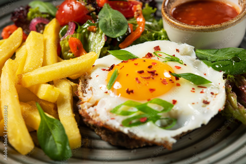 Hearty breakfast with fried eggs, french fries Hearty breakfast with fried eggs, french fries