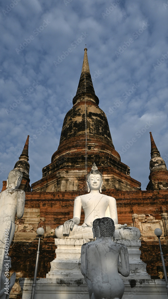 Vertical photograph of White Buddha statue at the base of the pagoda in Wat Yai Chaimongkol, Ayutthaya, Thailand, October 14, 2022.
