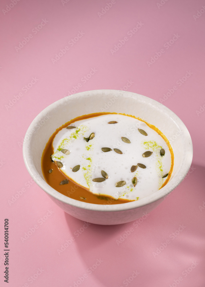 pumpkin cream soup on a pink background pumpkin cream soup on a pink background