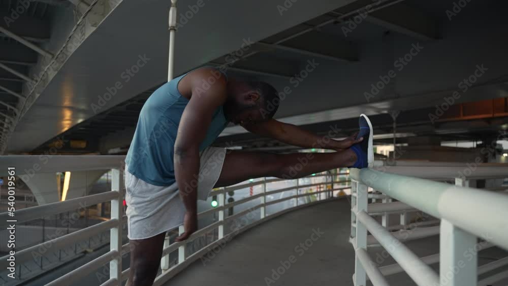 4k Male athlete is engaged in fitness and stretching on bridge in city spbas. Young american african man stretches legs and warms up muscles, does exercise and trains in modern town. Professional 4k Male athlete is engaged in fitness and stretching on bridge in city spbas. Young american african man stretches legs and warms up muscles, does exercise and trains in modern town. Professional
