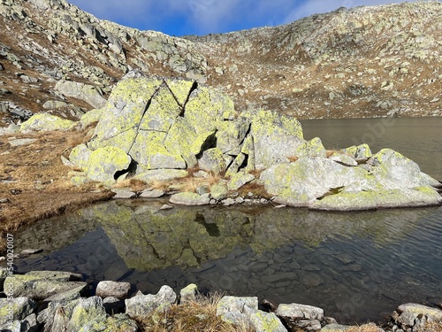 A crystal clear alpine lakes Laghi d'Orsirora during a beautiful autumn day in the mountainous area of the St. Gotthard Pass (Gotthardpass), Airolo - Canton of Ticino (Tessin), Switzerland (Schweiz) photo