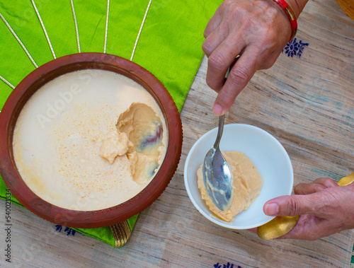 Homemade Mishti Doi or sweet dahi or curd made with milk and sugar or jaggery in earthen pot. It is popular Indian dessert of West Bengal, Assam and Odisha. photo