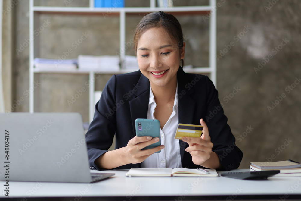 Woman holding credit card using laptop and mobile phone, Online shopping concept. Woman holding credit card using laptop and mobile phone, Online shopping concept.