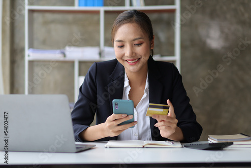 Woman holding credit card using laptop and mobile phone, Online shopping concept.