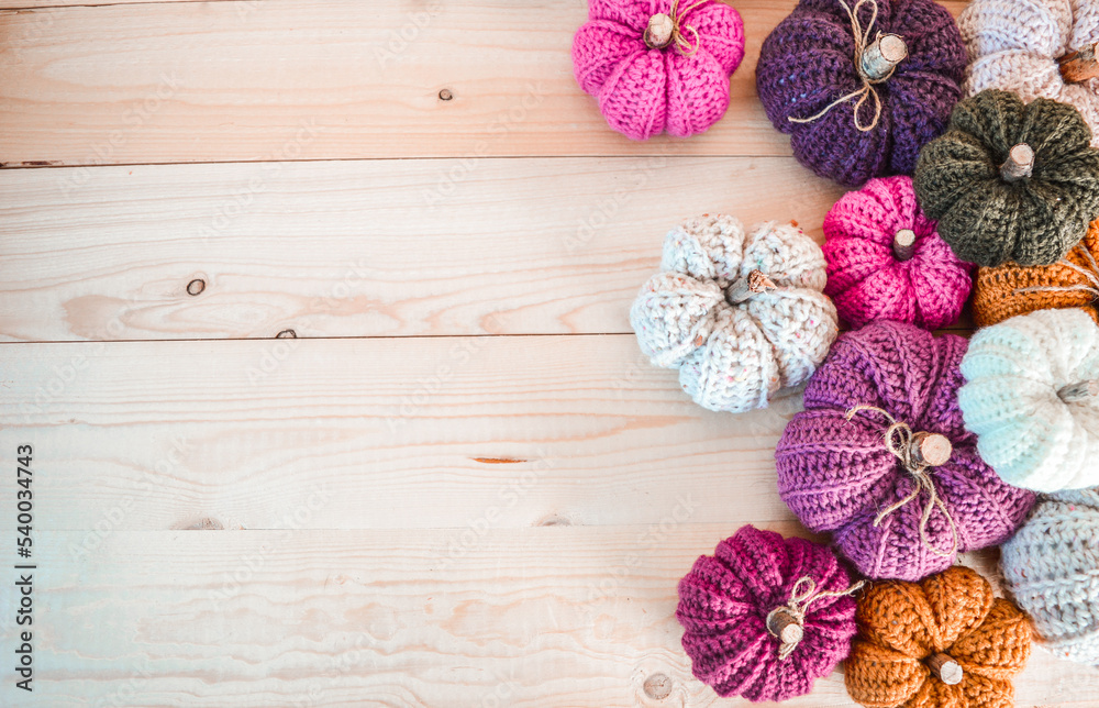 colorful handmade crochet pumpkins on light wooden ground with space for text colorful handmade crochet pumpkins on light wooden ground with space for text