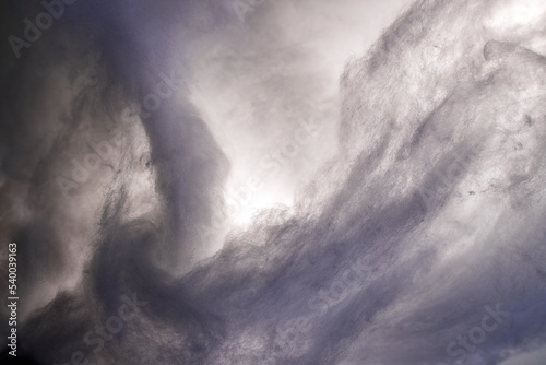 Abstract image made using colored light and cotton snow, artificial snow. Dramatic concept of clouds in the sky, storm at sea, light and dark, atmospheric states. Background or wallpaper.