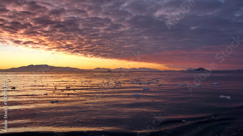 Colorful sunset over mountains and a field of floating icebergs at Cierva Cove  Antarctica