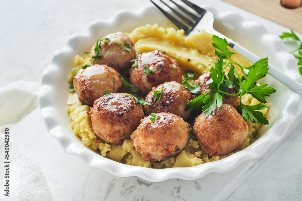Swedish meatballs in cream sauce, potatoes and lingonberry sauce in bowl on slate, stone or concrete backgrounds. Swedish cuisine. Delicious creamy mashed potatoes. Top view. Swedish meatballs in cream sauce, potatoes and lingonberry sauce in bowl on slate, stone or concrete backgrounds. Swedish cuisine. Delicious creamy mashed potatoes. Top view.