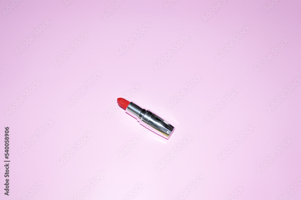 compact red lipstick in a shiny case on a pink background compact red lipstick in a shiny case on a pink background