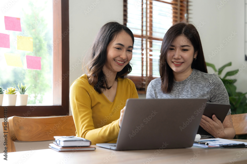 Two young Asian business woman talk, consult, discuss working with new startup project idea presentation analyze plan marketing and investment in the office. Two young Asian business woman talk, consult, discuss working with new startup project idea presentation analyze plan marketing and investment in the office.