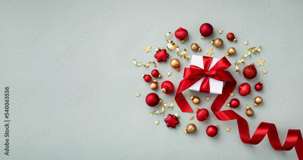 Christmas composition made of holiday ball and gift box with red ribbon in flat lay style. Creative greeting card. Christmas composition made of holiday ball and gift box with red ribbon in flat lay style. Creative greeting card.
