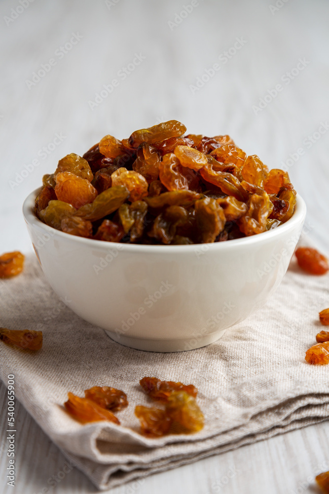 Organic Dried Raisins in a White Bowl, low angle view. Close-up. Organic Dried Raisins in a White Bowl, low angle view. Close-up.