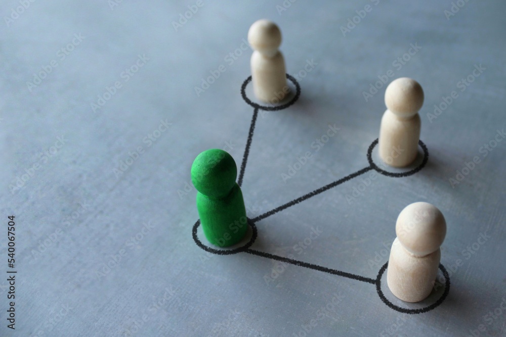 Obraz premium Green wooden doll connected with other wooden dolls. Communication social. Cooperation, collaboration. Project leadership personnel management concept