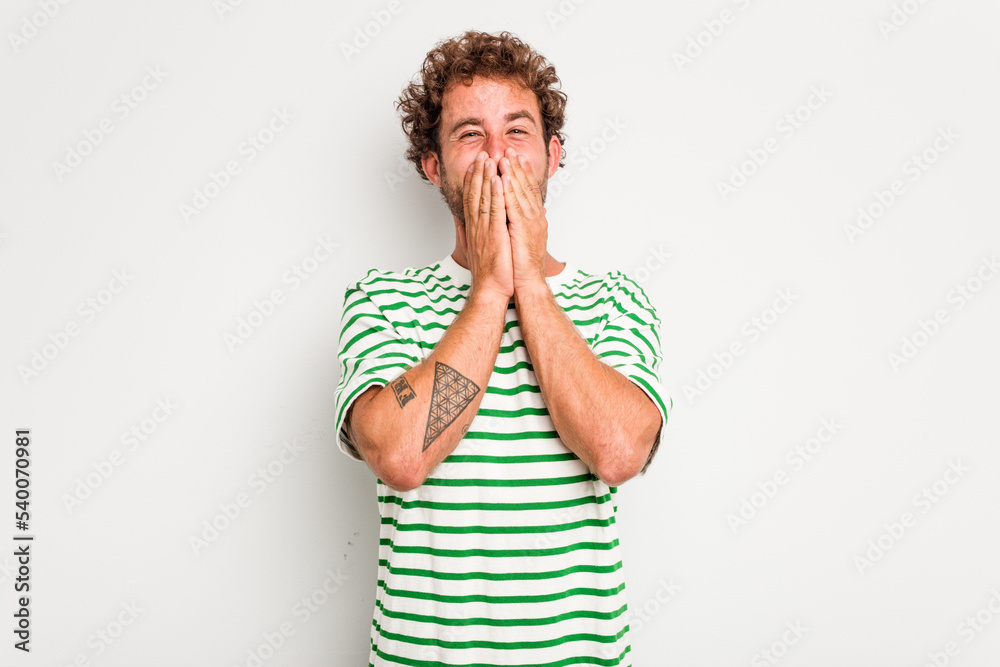 Young caucasian curly hair man isolated on white background laughing about something, covering mouth with hands. Young caucasian curly hair man isolated on white background laughing about something, covering mouth with hands.