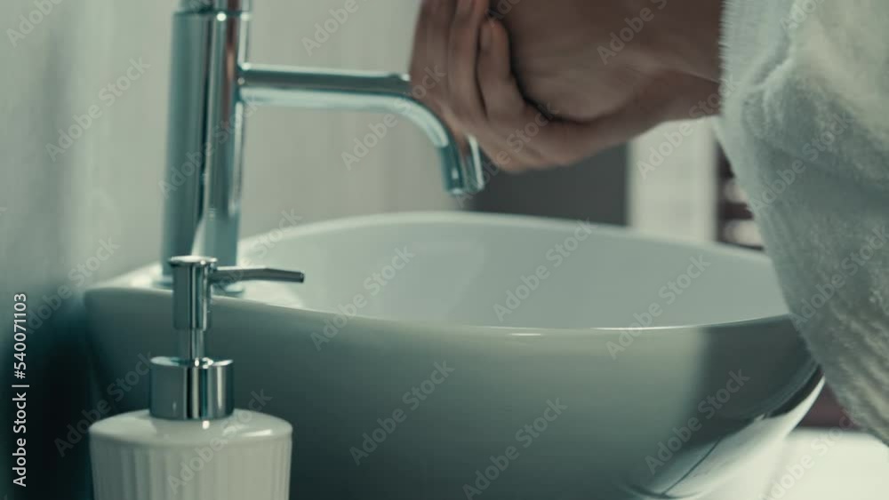 Unrecognizable man in bath washing hands. Close-up washing male arms with liquid soap gel eco-friendly product sanitizer for cleaning palms in hotel bathroom daily hygiene prevention germs Covid-19 Unrecognizable man in bath washing hands. Close-up washing male arms with liquid soap gel eco-friendly product sanitizer for cleaning palms in hotel bathroom daily hygiene prevention germs Covid-19