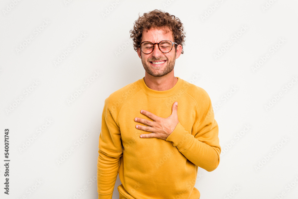 Young caucasian curly hair man isolated on white background laughs out loudly keeping hand on chest. Young caucasian curly hair man isolated on white background laughs out loudly keeping hand on chest.