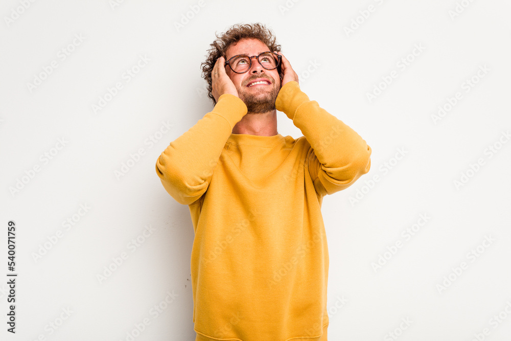 Young caucasian curly hair man isolated on white background laughs joyfully keeping hands on head. Happiness concept. Young caucasian curly hair man isolated on white background laughs joyfully keeping hands on head. Happiness concept.