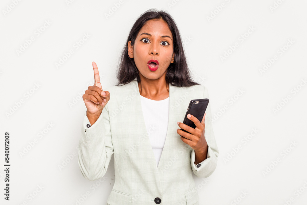 Young business Indian woman holding a mobile phone isolated on white background having some great idea, concept of creativity. Young business Indian woman holding a mobile phone isolated on white background having some great idea, concept of creativity.