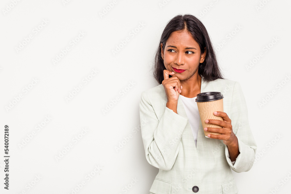 Young business Indian woman holding takeaway coffee isolated on white background relaxed thinking about something looking at a copy space. Young business Indian woman holding takeaway coffee isolated on white background relaxed thinking about something looking at a copy space.