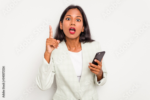 Young business Indian woman holding a mobile phone isolated on white background having an idea, inspiration concept.