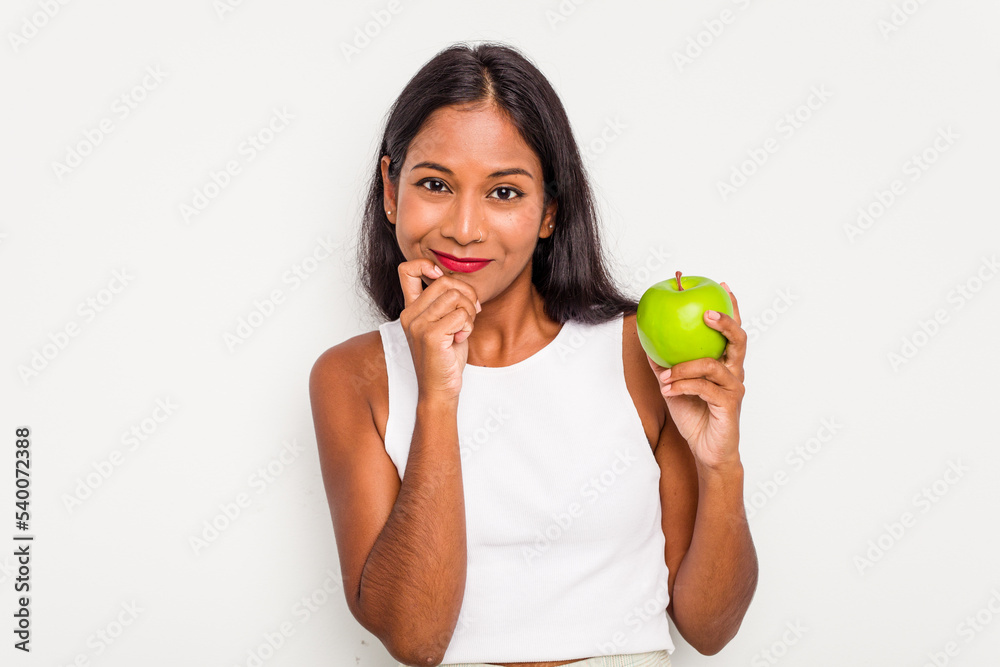 Young Indian woman holding an apple isolated on white background biting fingernails, nervous and very anxious. Young Indian woman holding an apple isolated on white background biting fingernails, nervous and very anxious.