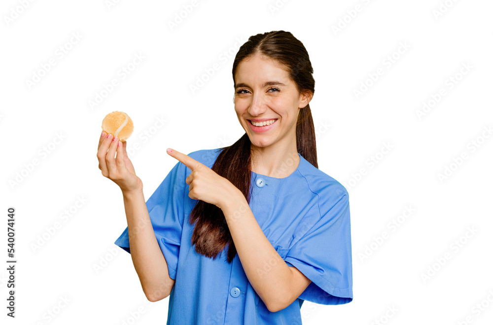 Young caucasian physiotherapist woman holding a tennis ball isolated smiling and pointing aside, showing something at blank space. Young caucasian physiotherapist woman holding a tennis ball isolated smiling and pointing aside, showing something at blank space.