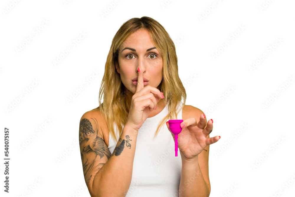 Young caucasian woman holding menstrual cup isolated on green chroma background keeping a secret or asking for silence. Young caucasian woman holding menstrual cup isolated on green chroma background keeping a secret or asking for silence.