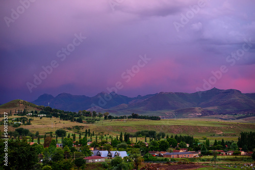 A view of the mountains under a stormy purple sky at sunset in Clarens, South Africa. The popular town is near the Golden Gate Highlands National Park, which is part of the Drakensberg range. photo