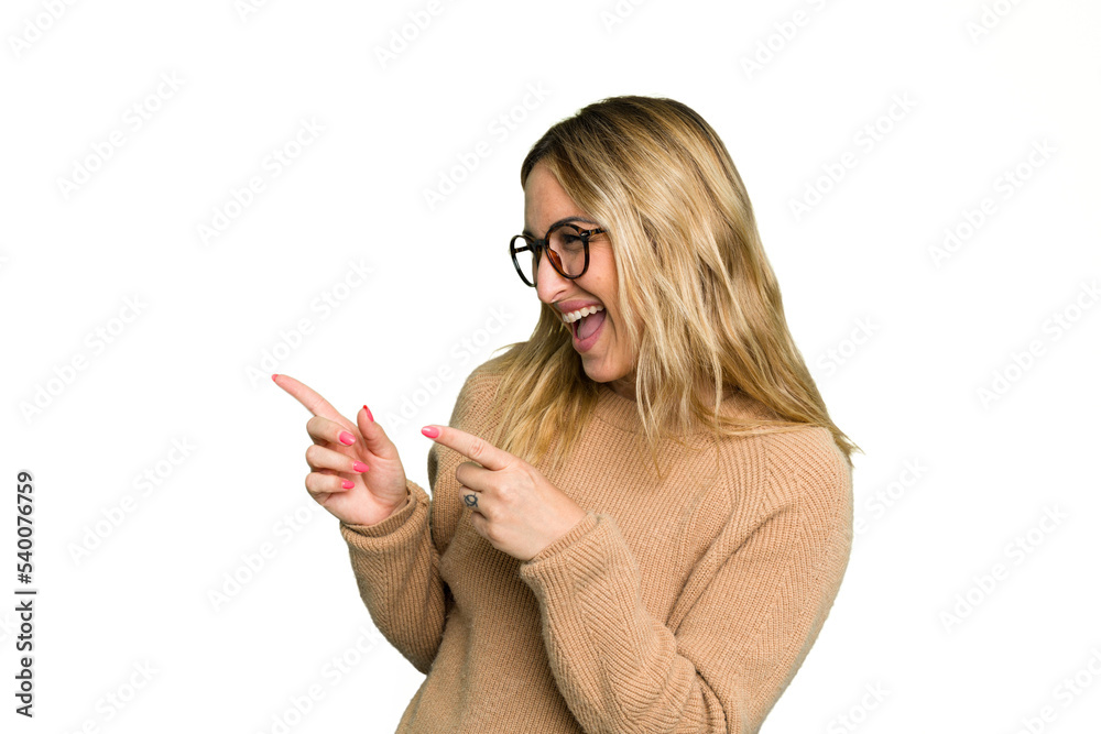 Young caucasian woman isolated on green chroma background points with thumb finger away, laughing and carefree. Young caucasian woman isolated on green chroma background points with thumb finger away, laughing and carefree.