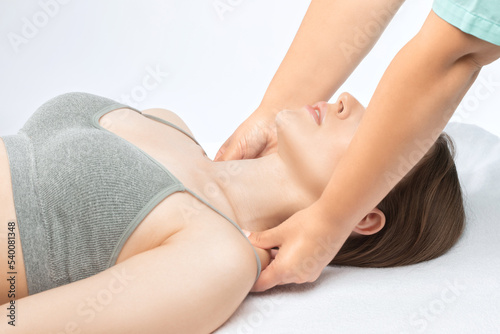 Masseur makes a relaxing massage on the neck, shoulders, back and collarbones of a young beautiful woman in a spa. Treatment for back pain.