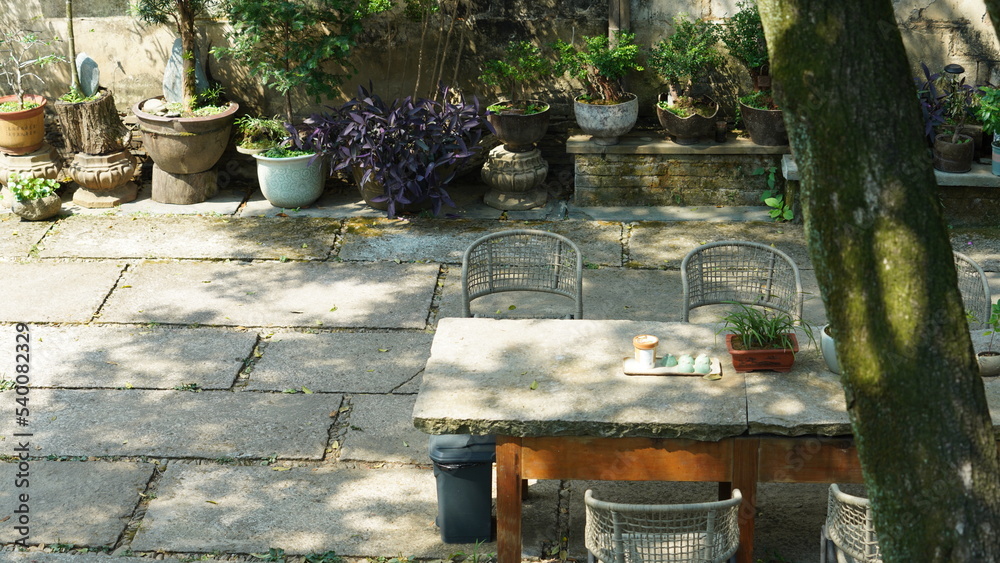The beautiful garden view with the flowers and stone tables in the countryside village of the China The beautiful garden view with the flowers and stone tables in the countryside village of the China