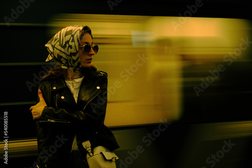 Fashionable Caucasian girl is waiting for the train photo