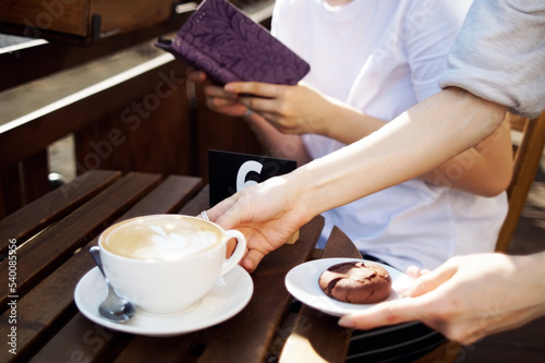 A teenager with blue hair in a cafe is waiting for an order photo