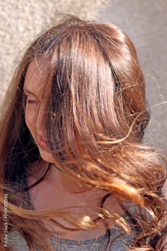 girls with long hair that develops in the wind in the rays of the sun, close-up portrait