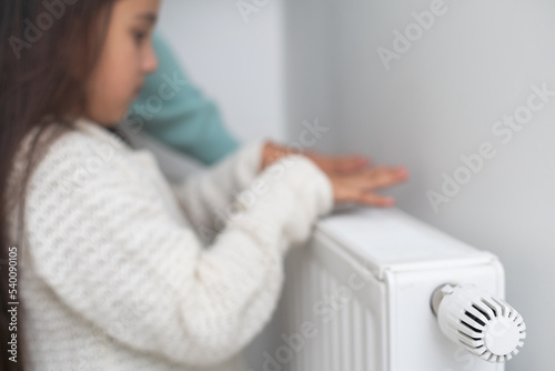 hands of a little girl near the radiator