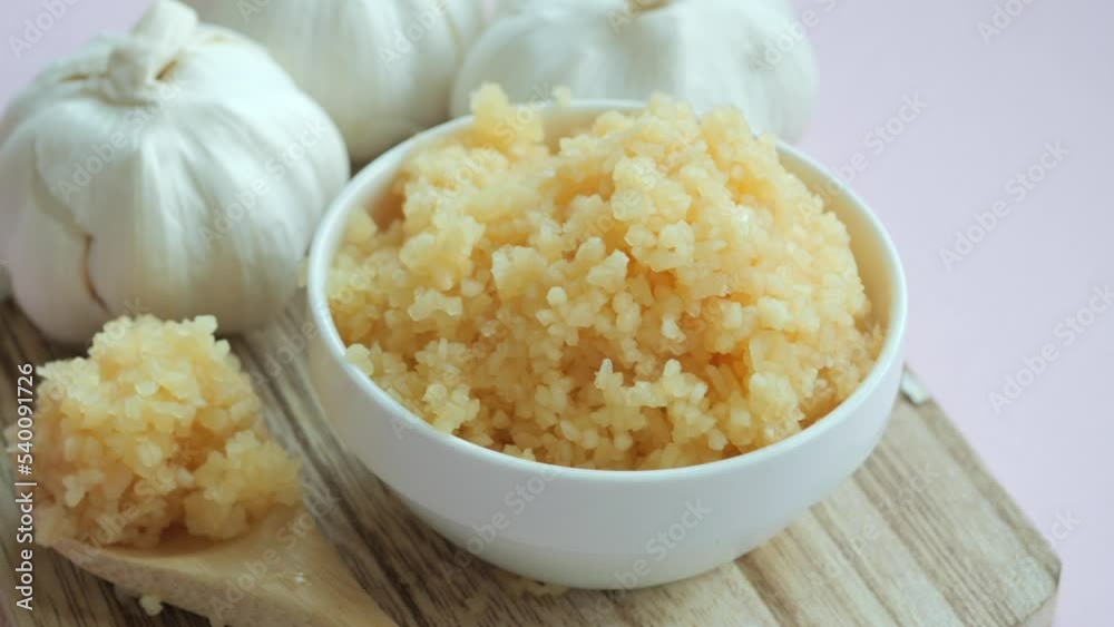 close up of minced garlic in a bowl on table close up of minced garlic in a bowl on table