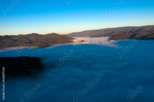 Aerial view of morning fog in the valley in dawn