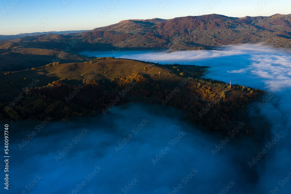 Aerial view of mist and clouds in the valley in sunrise