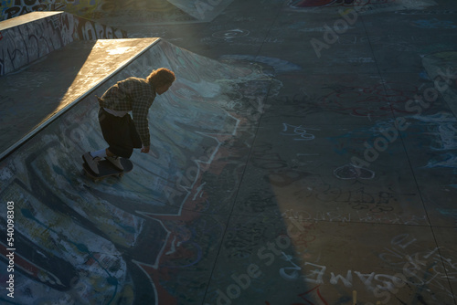 Portrait of young non-binary skating on skateboard at skatepark
