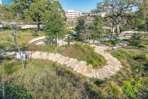 Stone brick walking trail on grassy land at Waterloo Park in Austin Texas