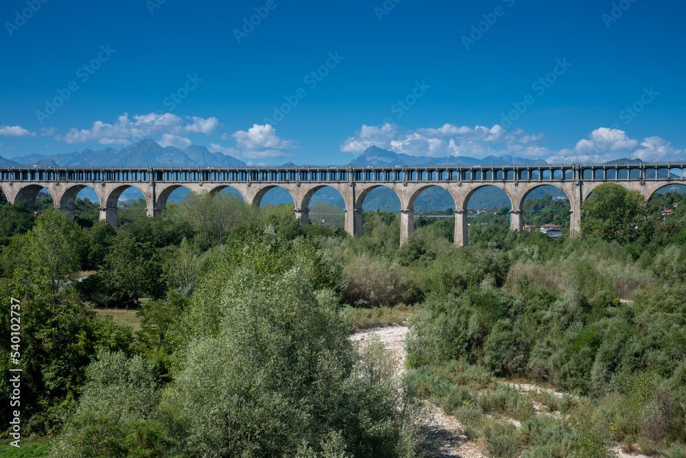 Cuneo, Piedmont, Italy :  The Soleri viaduct, it is a promiscuous road and rail bridge on the Stura di Demonte river, in the background the mountains of the Alps