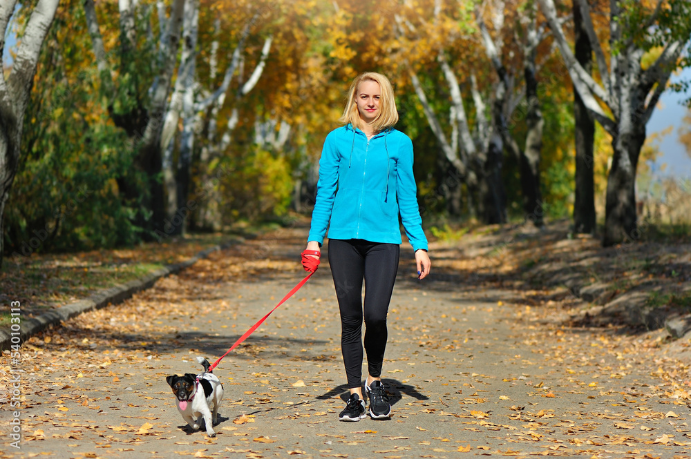 Woman walking with her dog at the park alley Woman walking with her dog at the park alley