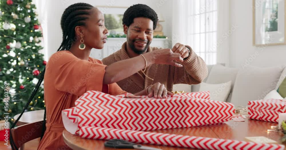 Christmas, gift and black couple packaging a box present with a ribbon to celebrate happy holidays at home. Smile, package and excited black woman wrapping gifts or presents with her African partner